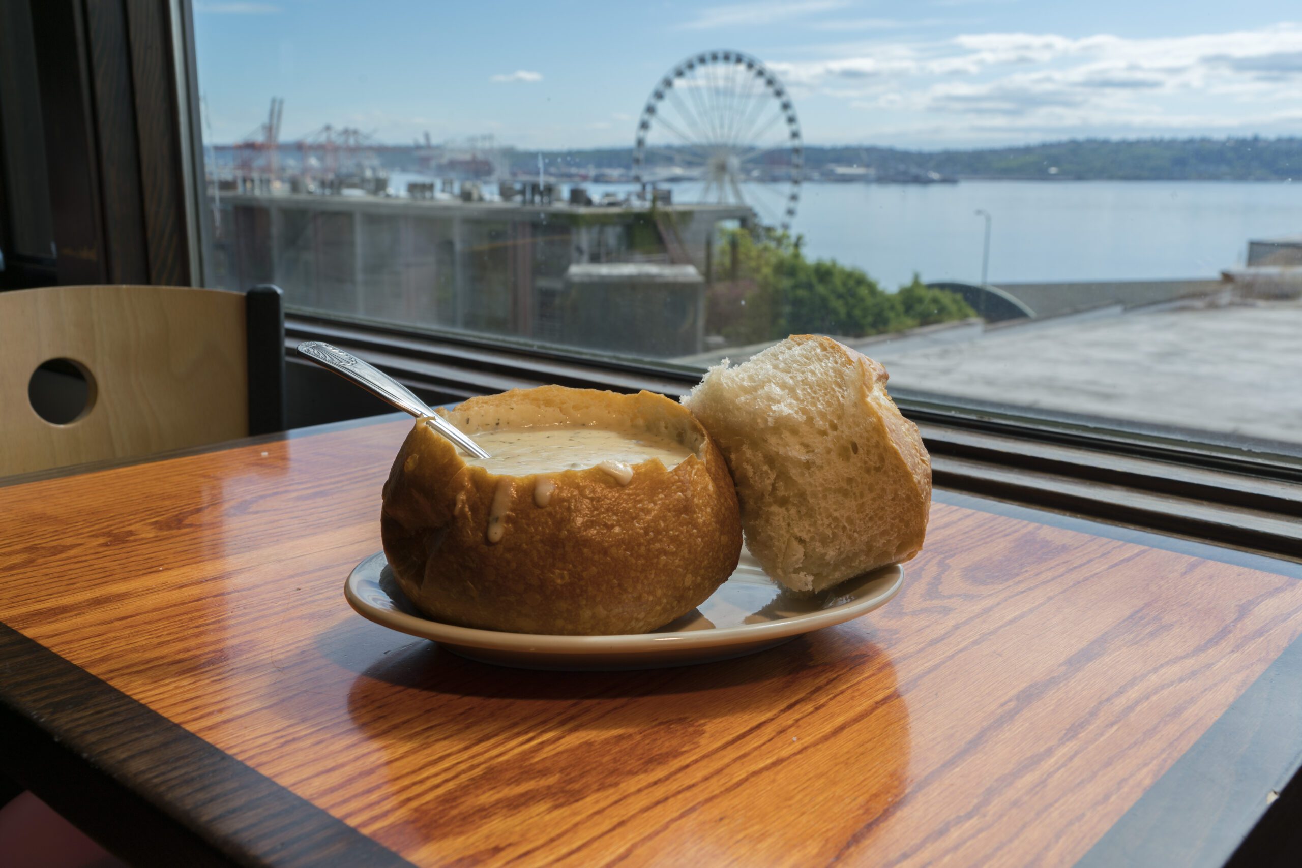 Clam chowder siting on table in front of a stunning view of Puget Sound at Sound View Cafe in Pike Place Market.