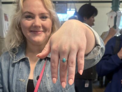 A women holds up her hand to show off a ring purchased from Rachel's Raindrop Jewelry, a handmade craft business in Pike Place Market.